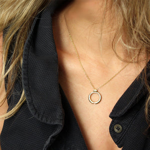 Personalized couples circle pendant necklace worn on neck in solid yellow gold, interlocking pendants that form a heart when brought together with engraved romantic message