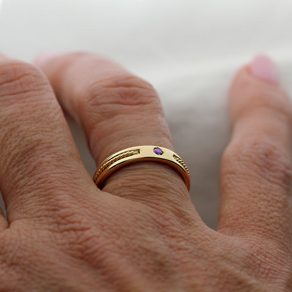 Minimalist 18k gold sapphire wedding band featuring slim stacking ring design with bezel set purple sapphire and rope filigree accents