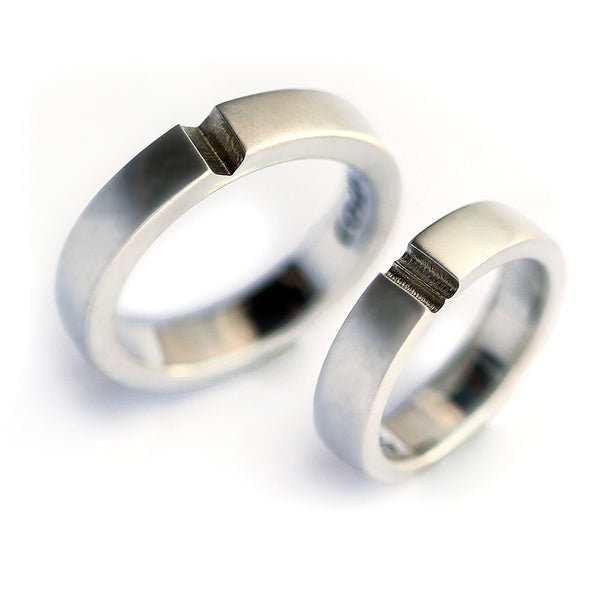 Modern silver couple wedding rings featuring hidden heart closure detail, minimalist symbolic relationship rings