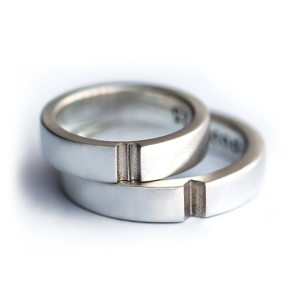 Stacked silver matching rings with hidden heart alignment detail, elegant minimalist engagement or promise ring set