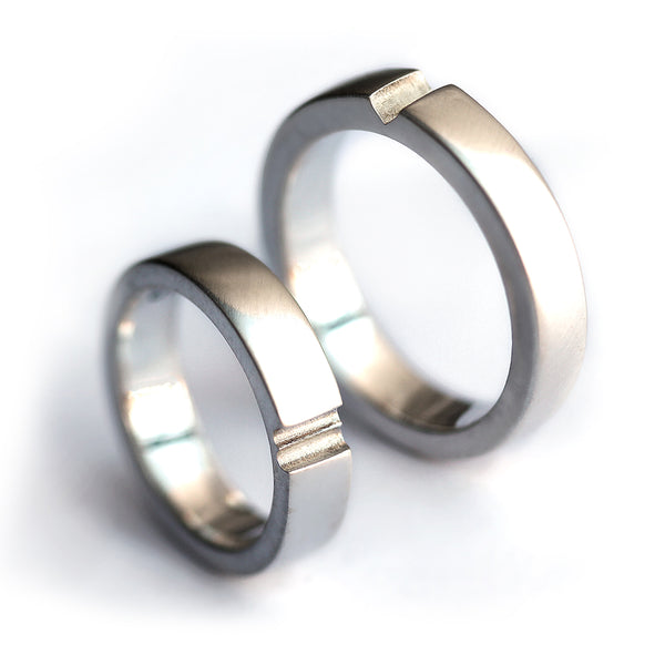 Polished silver his and hers couple rings showing hidden heart connection groove, contemporary matching wedding bands
