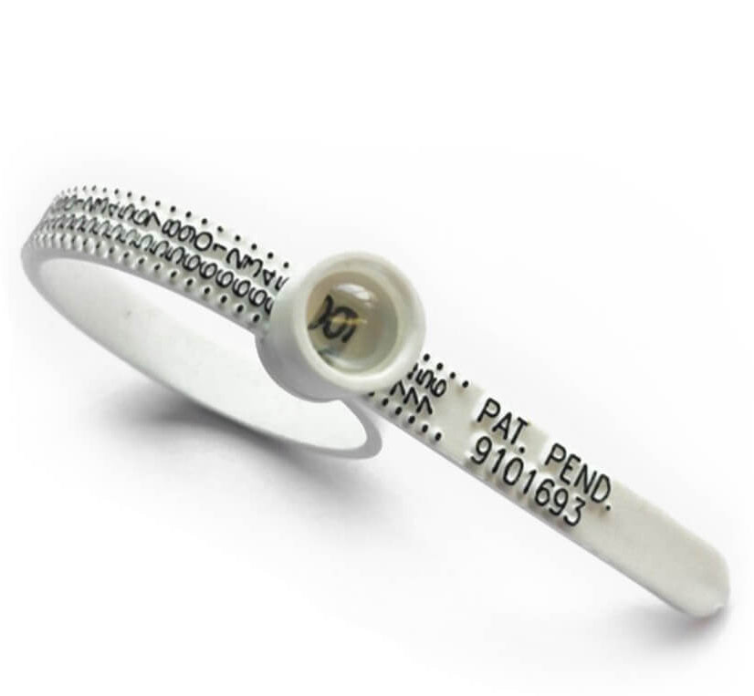 ring sizer on a hand with pink nail polish against a white background