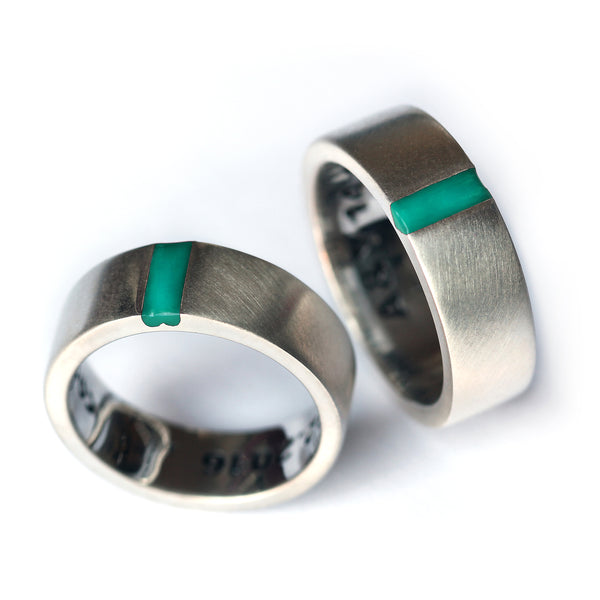 Luxury matching couple rings with turquoise enamel accent, silver wedding bands forming hidden heart symbol together.