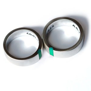 White gold or sterling silver matching rings with turquoise enamel detail revealing hidden heart design when aligned.