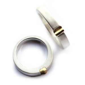 White gold magnetic couple rings, one band shows yellow gold half-heart edge, matching set for wedding or anniversary