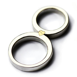 Two matching rings forming a yellow gold heart, magnetic two tone wedding bands