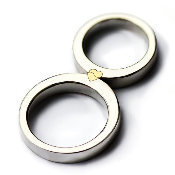 Two matching rings forming a yellow gold heart, magnetic two tone wedding bands