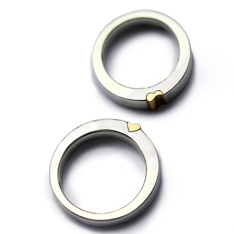 Two matching rings forming a yellow gold heart, magnetic two tone wedding bands