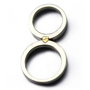Magnetic interlocking wedding rings, white gold bands aligned to form a yellow gold heart, two-tone couple rings