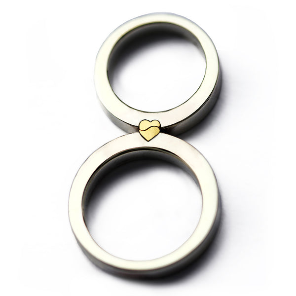 Magnetic interlocking wedding rings, white gold bands aligned to form a yellow gold heart, two-tone couple rings