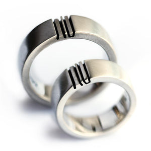 Detail of the engraved symbols aligned across the matching couple rings