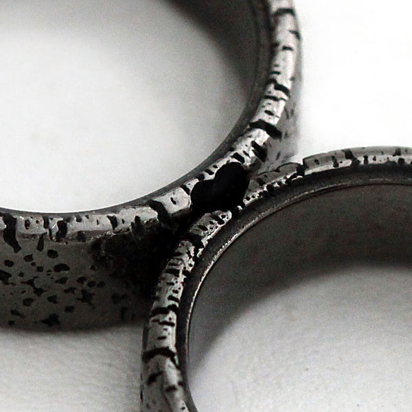 Cadi textured black rhodium wedding rings joined to reveal a hidden heart