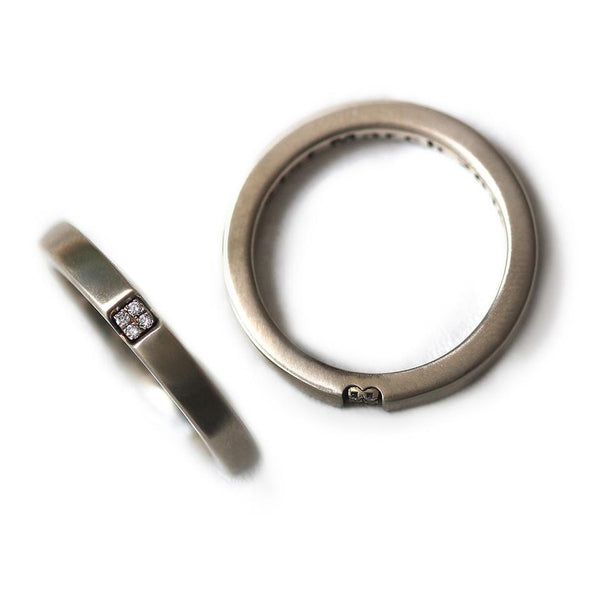 Detail of the white diamond settings and contemporary brushed finish across both bands