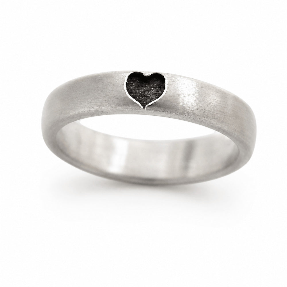 Cadi silver promise ring from a matching set with a dark heart-shaped recess on the brushed band