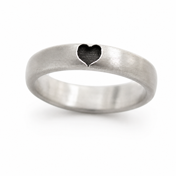Cadi silver promise ring from a matching set with a dark heart-shaped recess on the brushed band