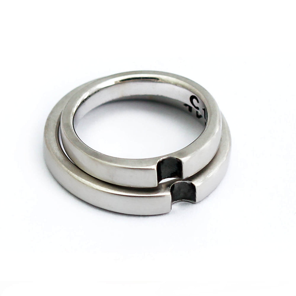 Infinity shape: handcrafted Cadi couples' set, two interlocking 18k silver bands with a black stone, wedding rings.