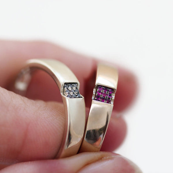Detail of the square-set rubies and black diamonds across the joined bands