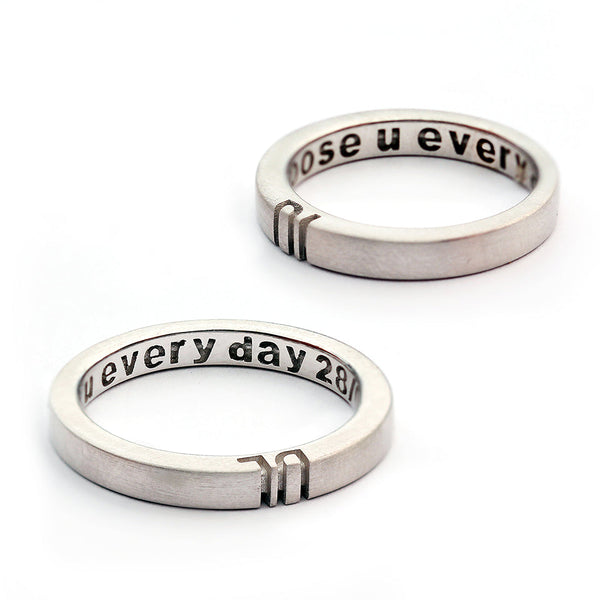 Detail of the engraved letter halves aligned between the two rings