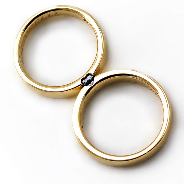 Detail of the diamond heart settings across the matching yellow gold bands