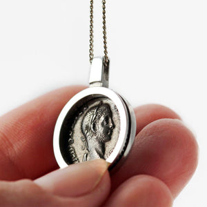 his Coin surrounded by a clean and classic design pendent is a replica of a genuine antique Roman coin