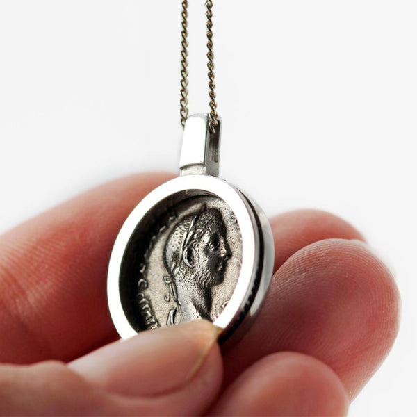 his Coin surrounded by a clean and classic design pendent is a replica of a genuine antique Roman coin