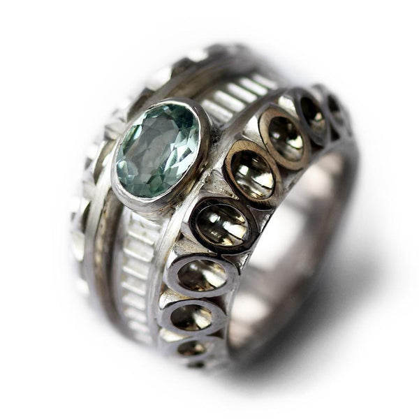 Cadi Donut cocktail ring showcases a bold oval aquamarine stone set in a smooth, rounded sculptural band with raised circles.