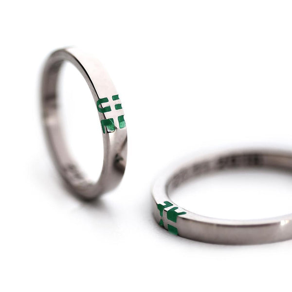 silver ring set with green initials