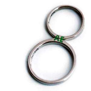 silver ring set with green initials