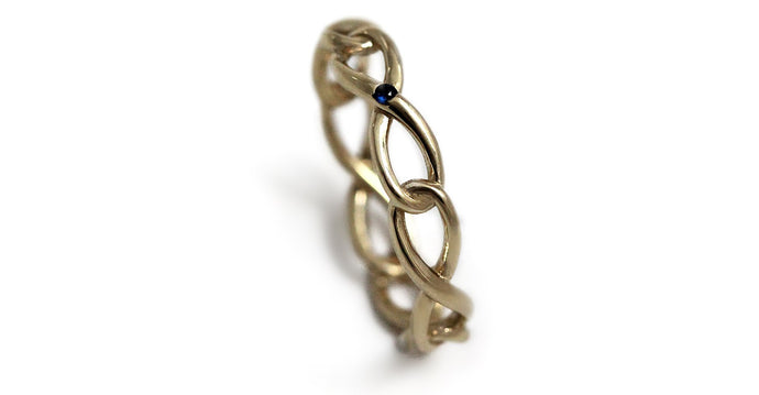 Delicate solid gold infinity shaped ring with blue Sapphire gemstone