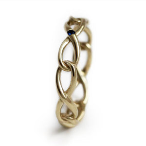Delicate solid gold infinity shaped ring with blue Sapphire gemstone
