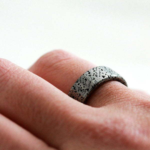Hand wearing Gorgonzola black and silver textured  wedding band