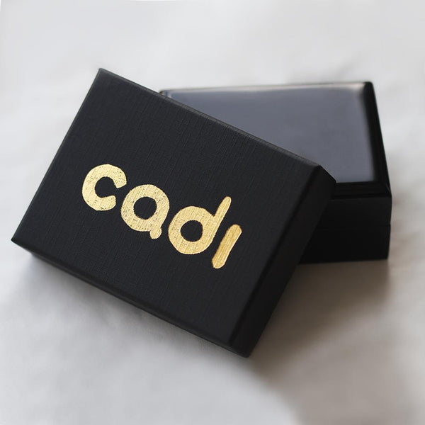 packaging of a Name bar necklace with a secret massage gift that is made in 18k gold with a geometric font shape by cadi jewelry